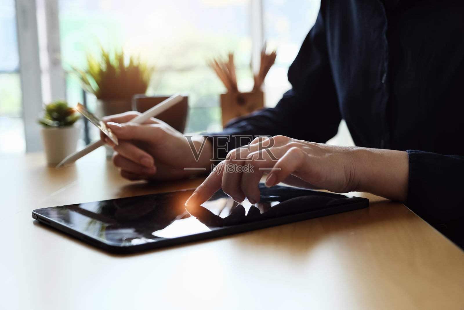 在线支付,年轻女性使用平板电脑和手持摇篮卡进行网上购物。照片摄影图片