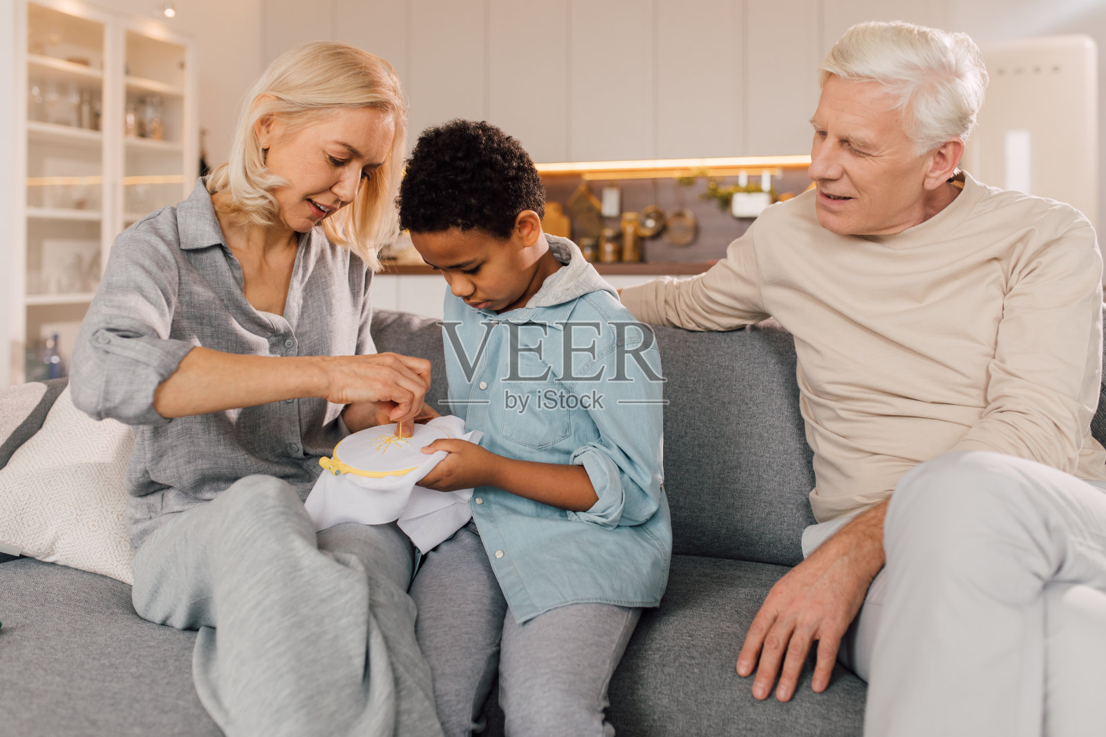 小男孩在奶奶在家做针线活的时候问她照片摄影图片