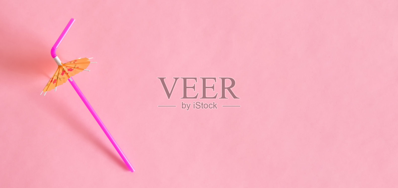 粉色背景上的鸡尾酒吸管和雨伞顶视图照片摄影图片