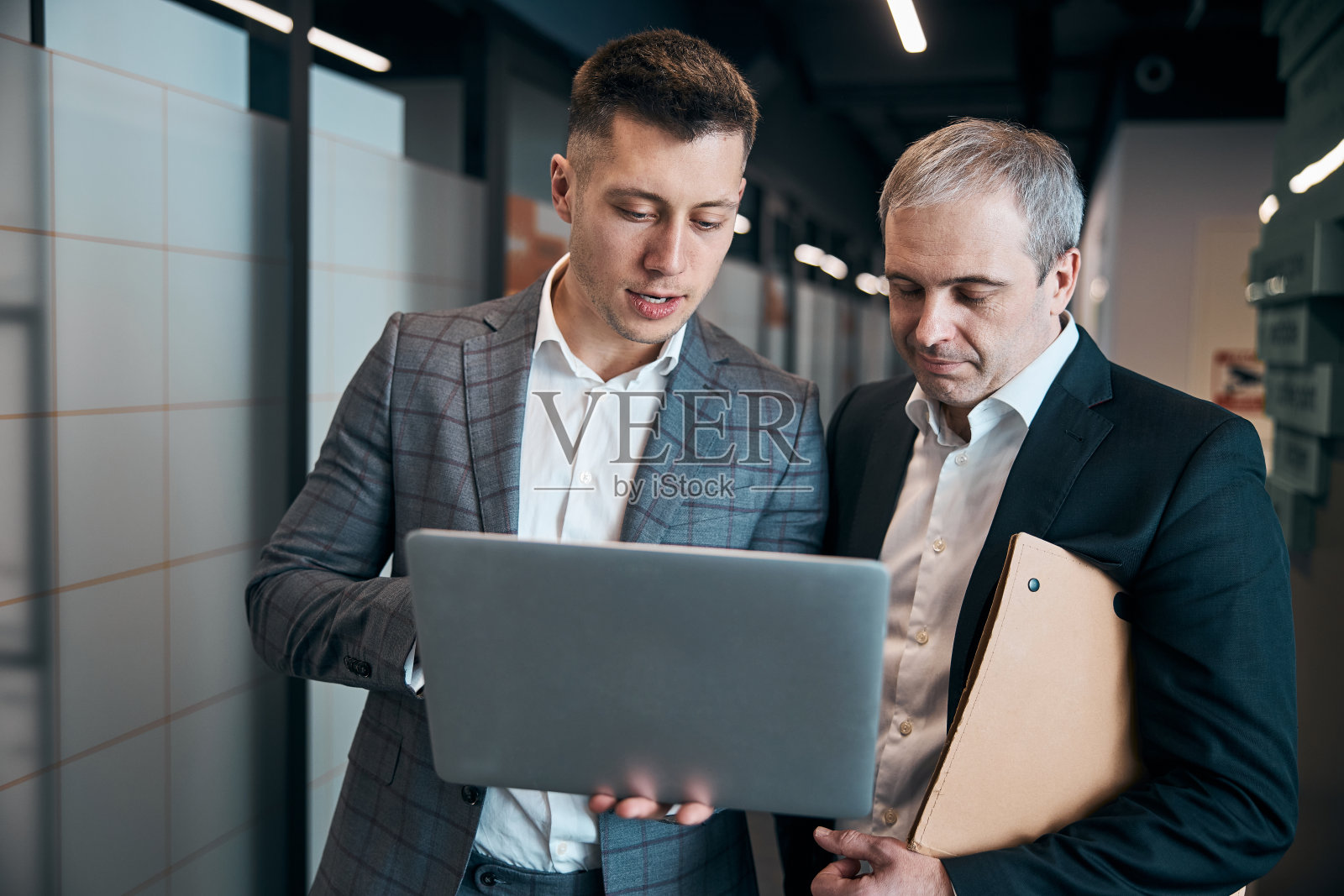 商务同事在办公室走廊使用笔记本电脑照片摄影图片