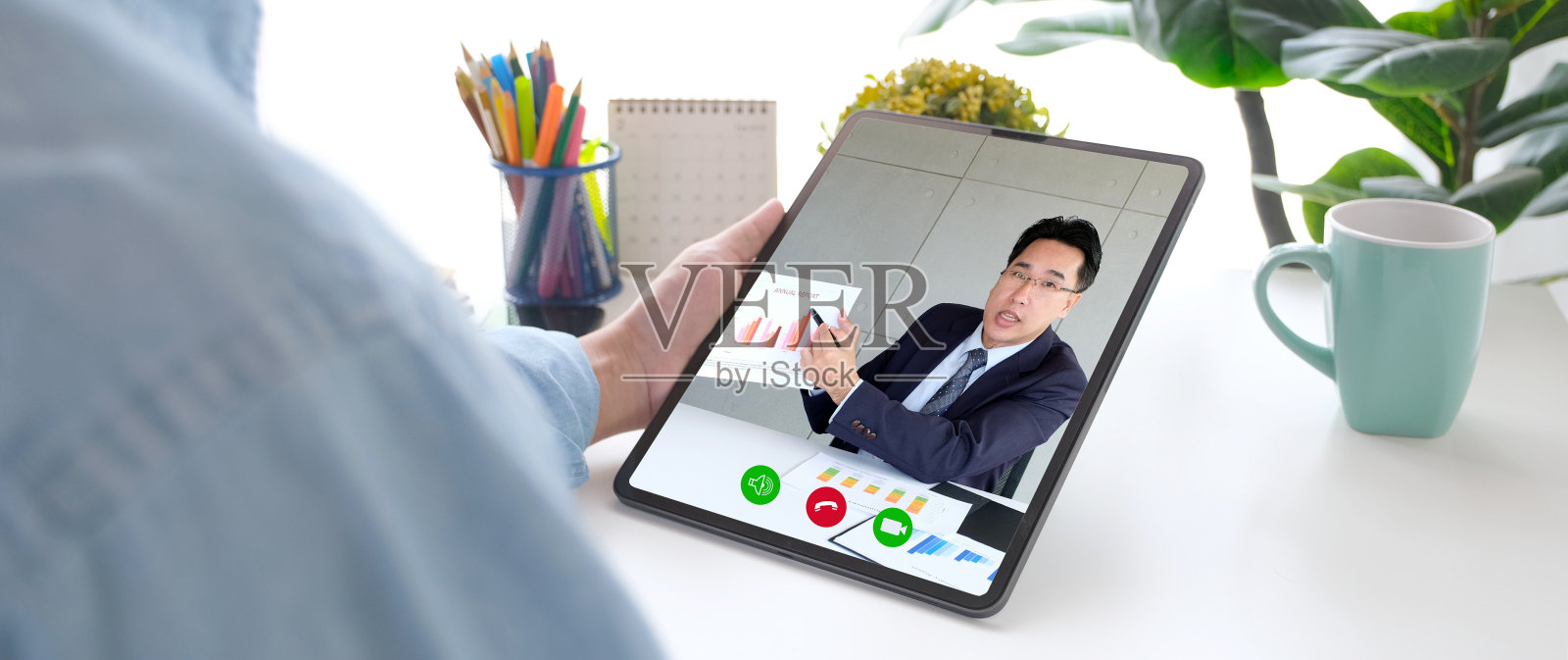 视频会议,在家工作,亚洲人手持数字平板电脑业务图表,同时通过虚拟网络与业务团队进行视频通话,通过会议在家里联系同事照片摄影图片