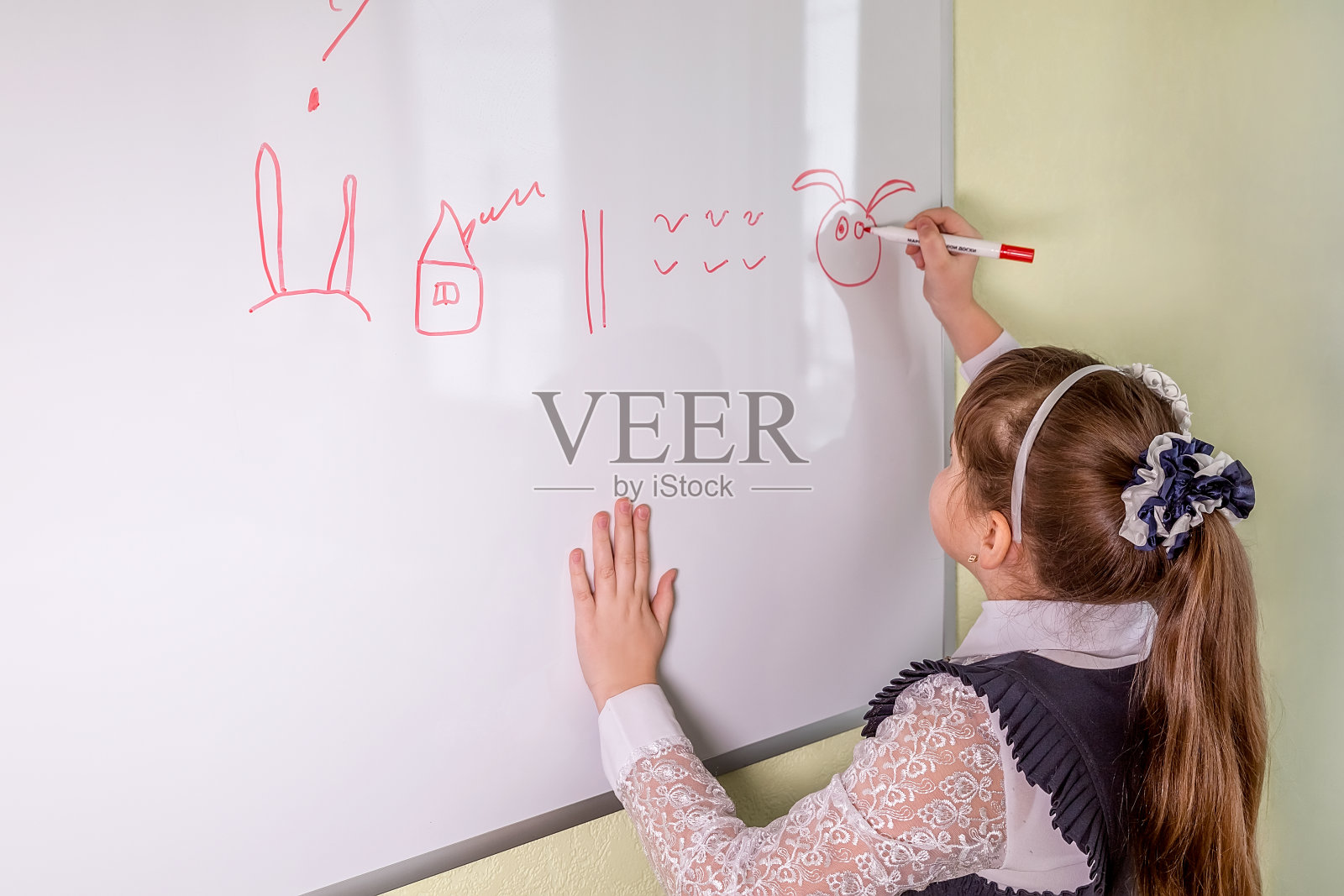 一个女学生站在黑板前,根据图画讲故事照片摄影图片