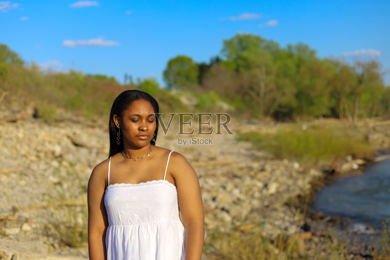 一位漂亮的黑人年轻女子独自站在外面,看起来很悲伤照片摄影图片