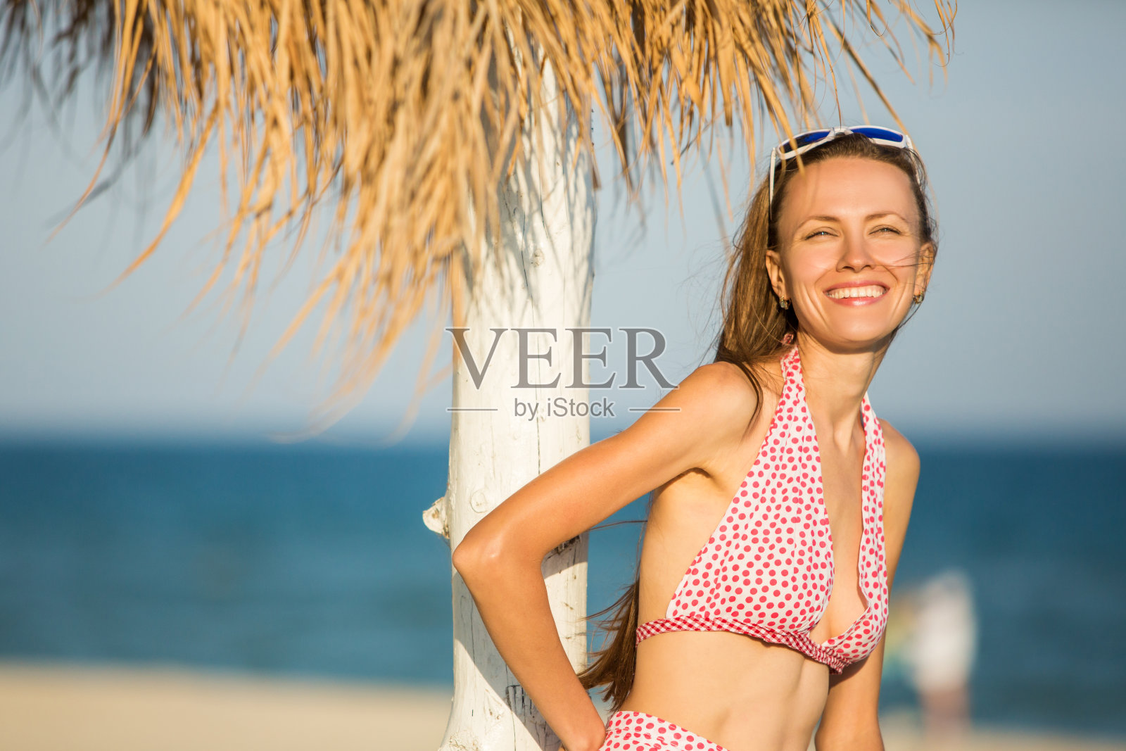 微笑的女人肖像与飞扬的头发在海滩上照片摄影图片