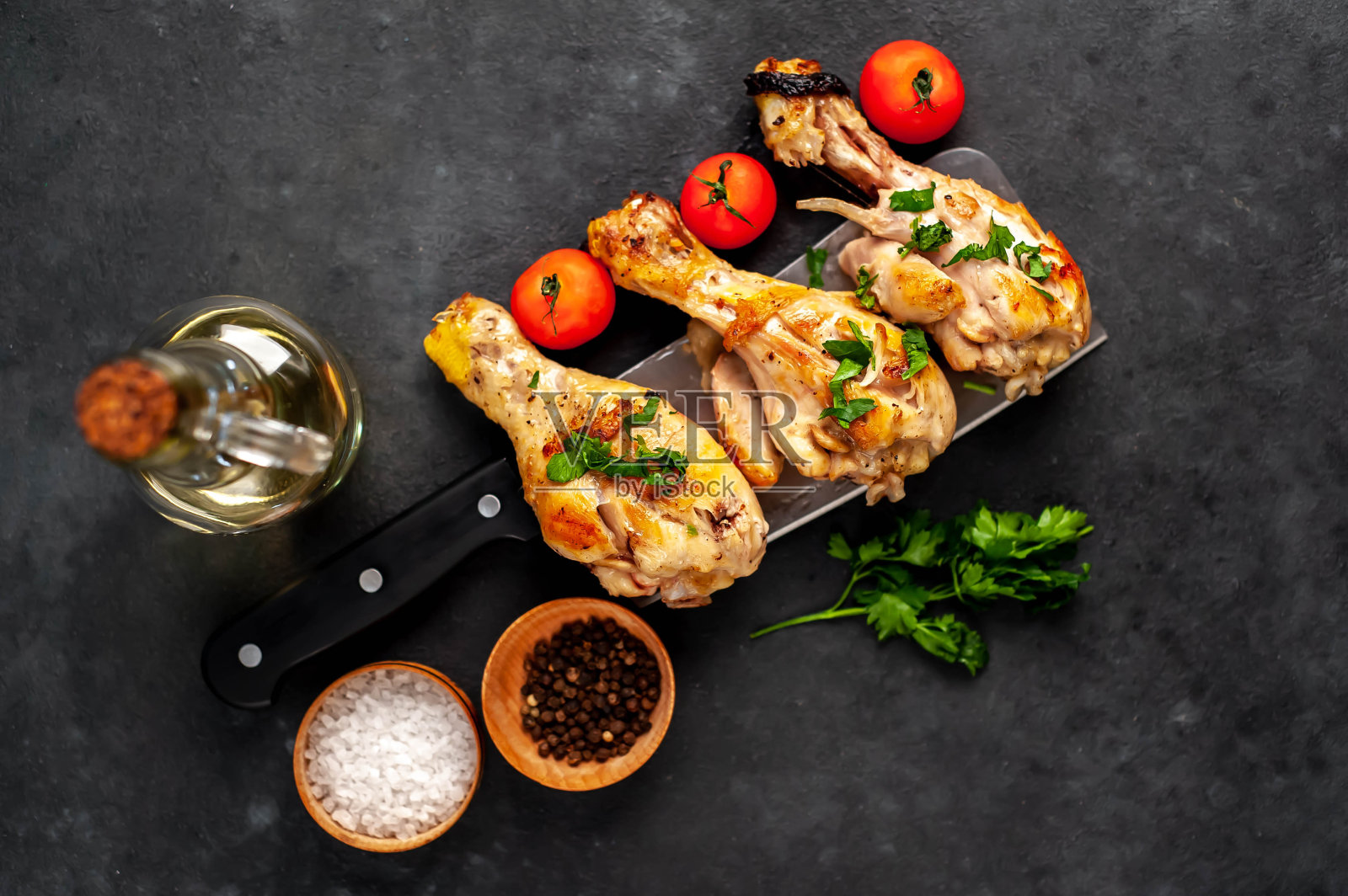 烤鸡腿与香料刀在石头背景照片摄影图片