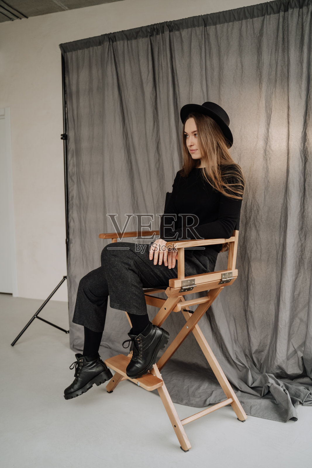 一个女人坐在椅子上,在摄影室摆姿势照片摄影图片