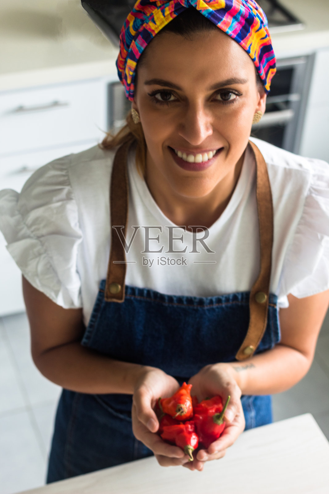 一个手里拿着辣椒的女人的垂直镜头照片摄影图片