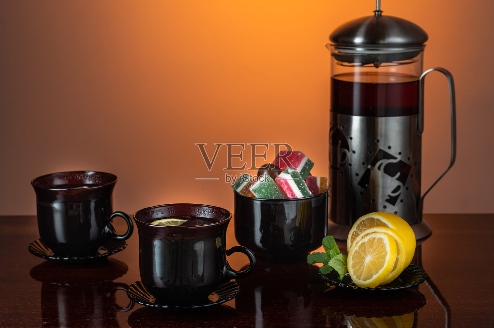 黑色的玻璃杯子。用柠檬茶。茶具。照片摄影图片