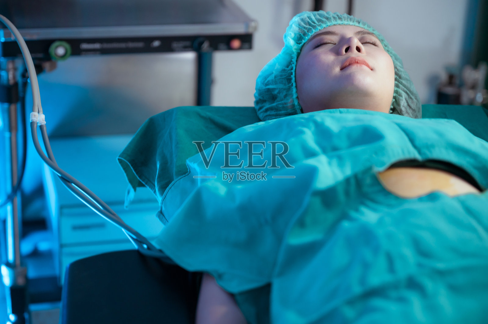 妇女躺在等待手术,医生准备手术。照片摄影图片