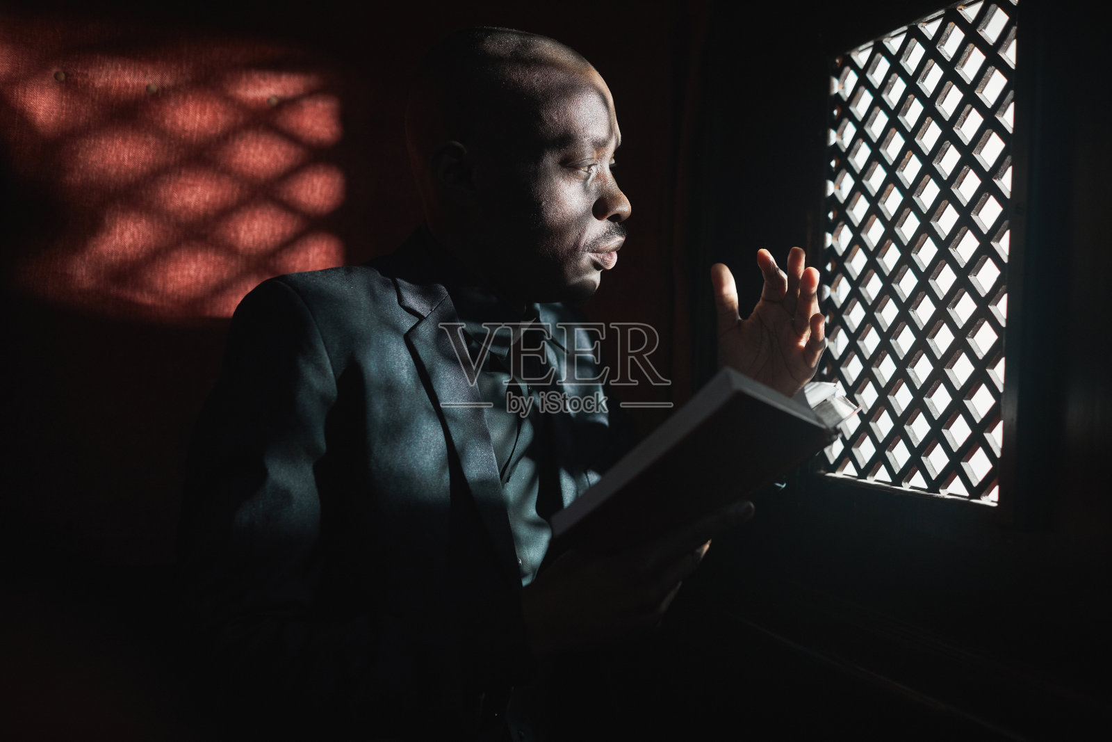 在忏悔室里读圣经的人照片摄影图片