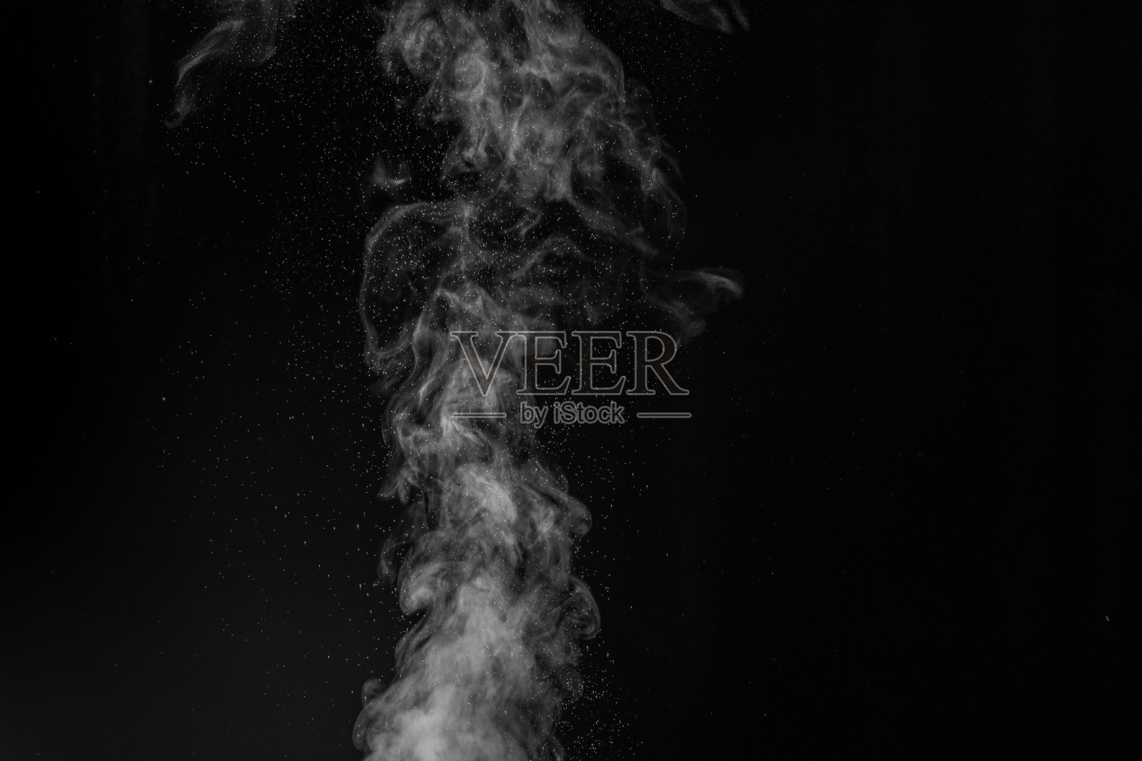 卷曲的白色蒸汽上升和飞溅的水散射在不同的方向孤立在一个黑色的背景。照片摄影图片
