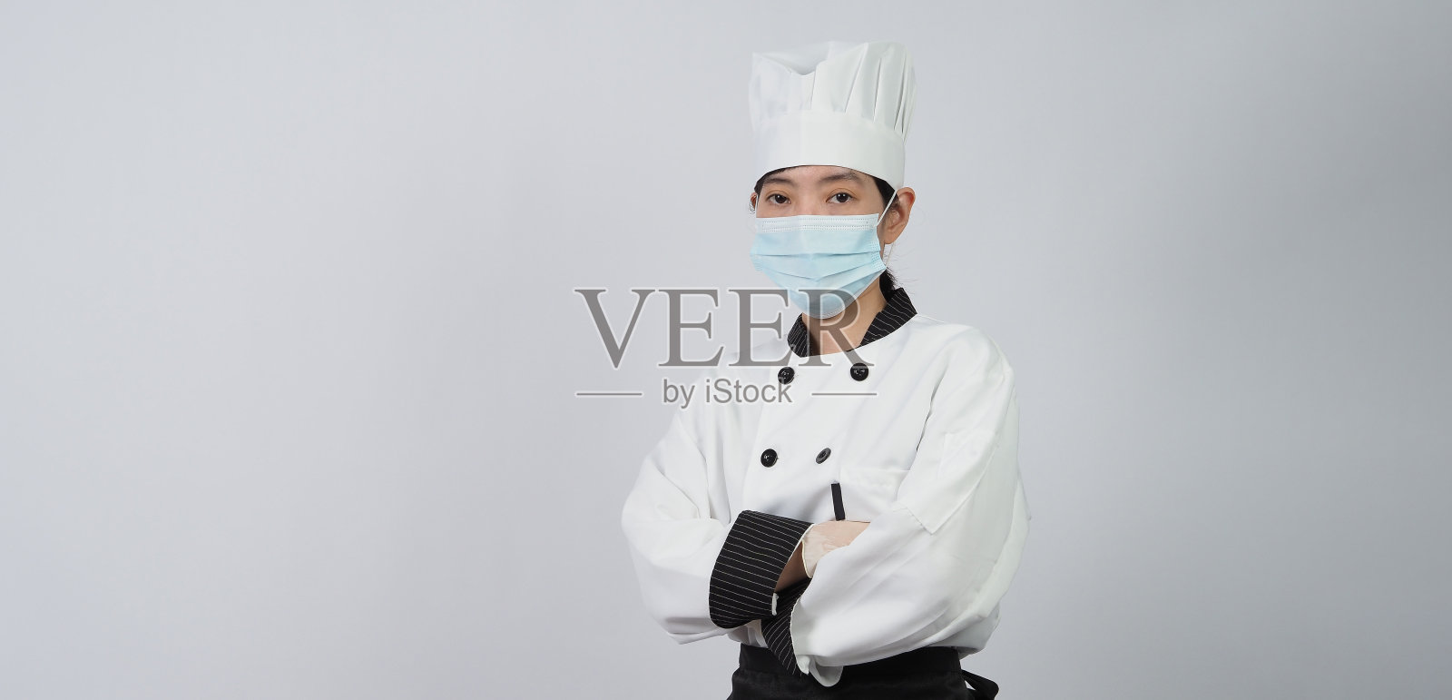 厨师戴上防护口罩或呼吸器以防止病毒感染。食品安全和冠状病毒大流行。厨师摆姿势表示在线下单。保健食品。照片摄影图片