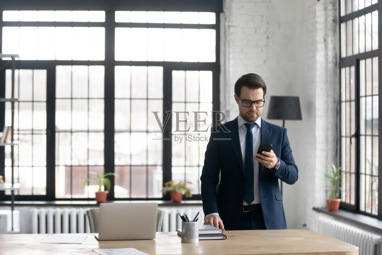 西装革履的白人商人在办公室使用智能手机照片摄影图片