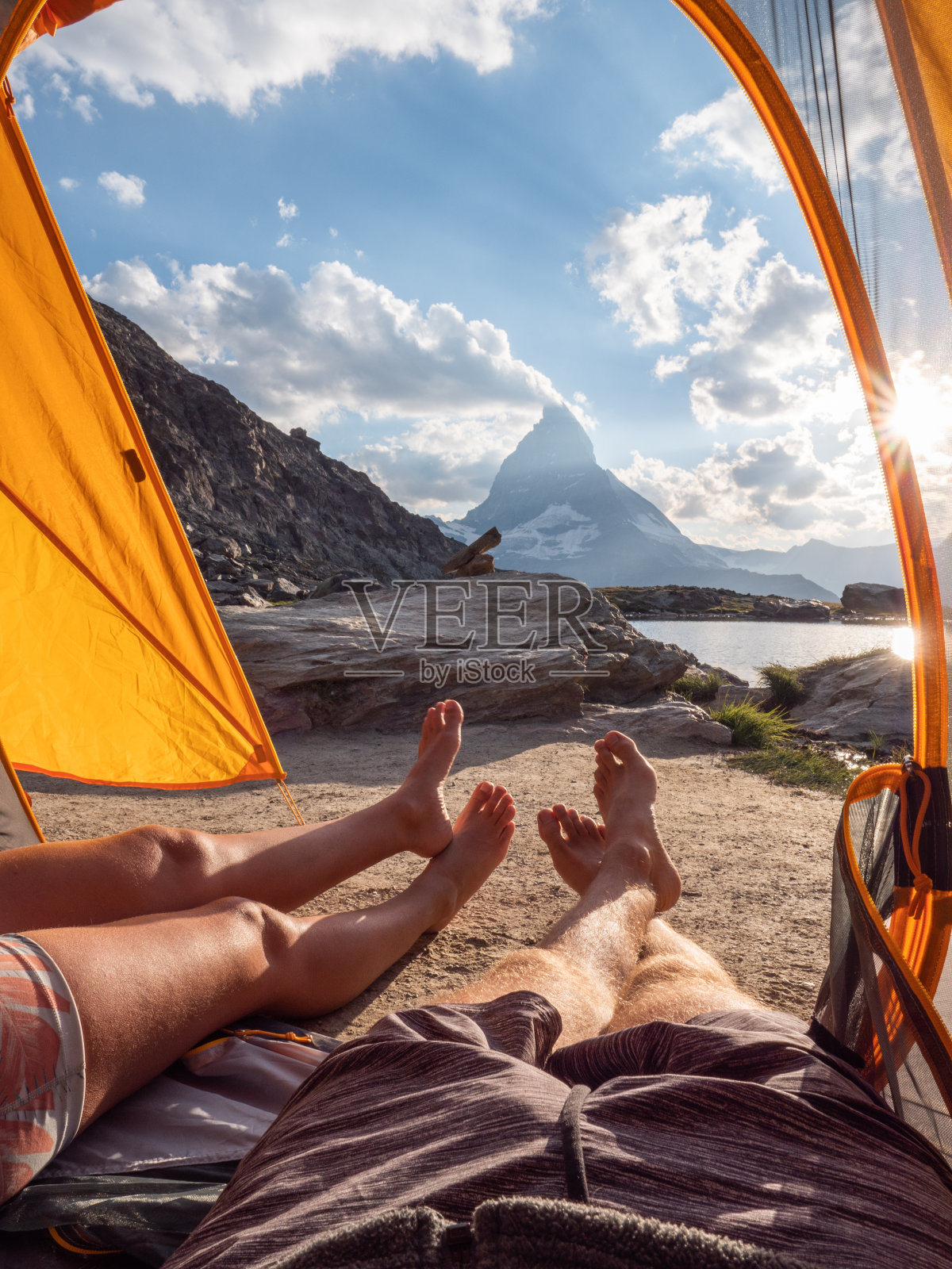 一对夫妇露营在高山附近的湖,POV从帐篷内照片摄影图片