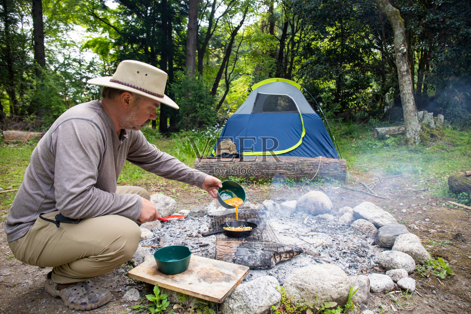 一个男人在野外生火做饭照片摄影图片
