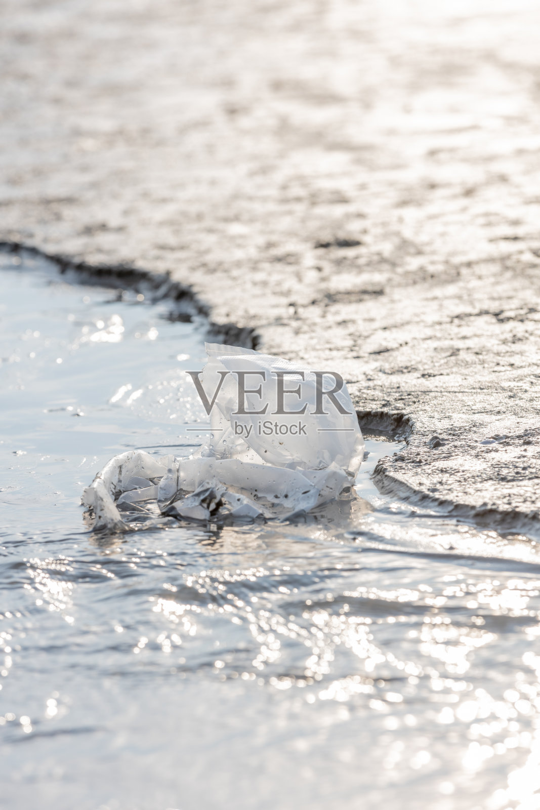 沙滩上的白色塑料袋照片摄影图片