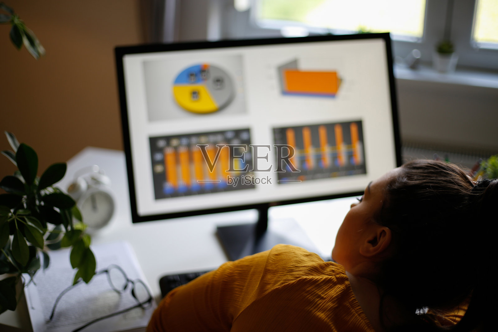 疲惫的女商人在办公室里拿着笔记本电脑。库存图片照片摄影图片