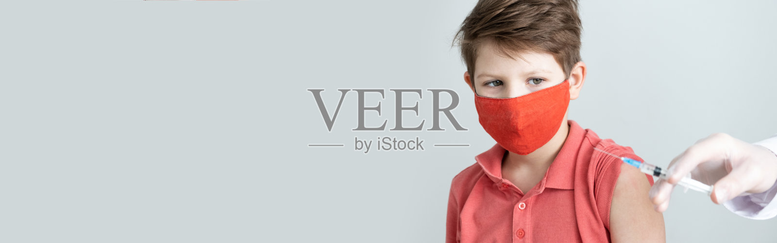 横幅。2019冠状病毒病大流行期间,一名戴着医用口罩的儿童接种了抗冠状病毒疫苗。医生在医疗手套与注射器进行注射。本空间照片摄影图片