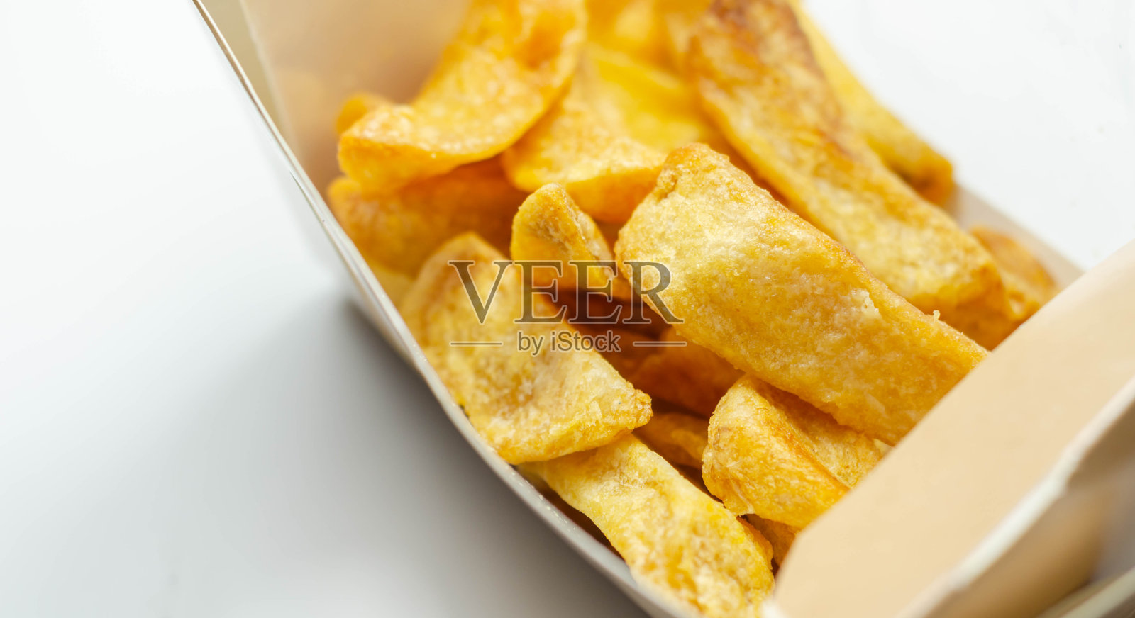 炸得香脆可口的薯条装在纸板箱里,外卖食品照片摄影图片