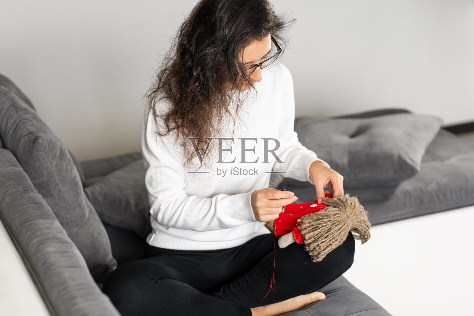 手工艺品是一种令人着迷的爱好。这个人在闲暇时缝制娃娃照片摄影图片