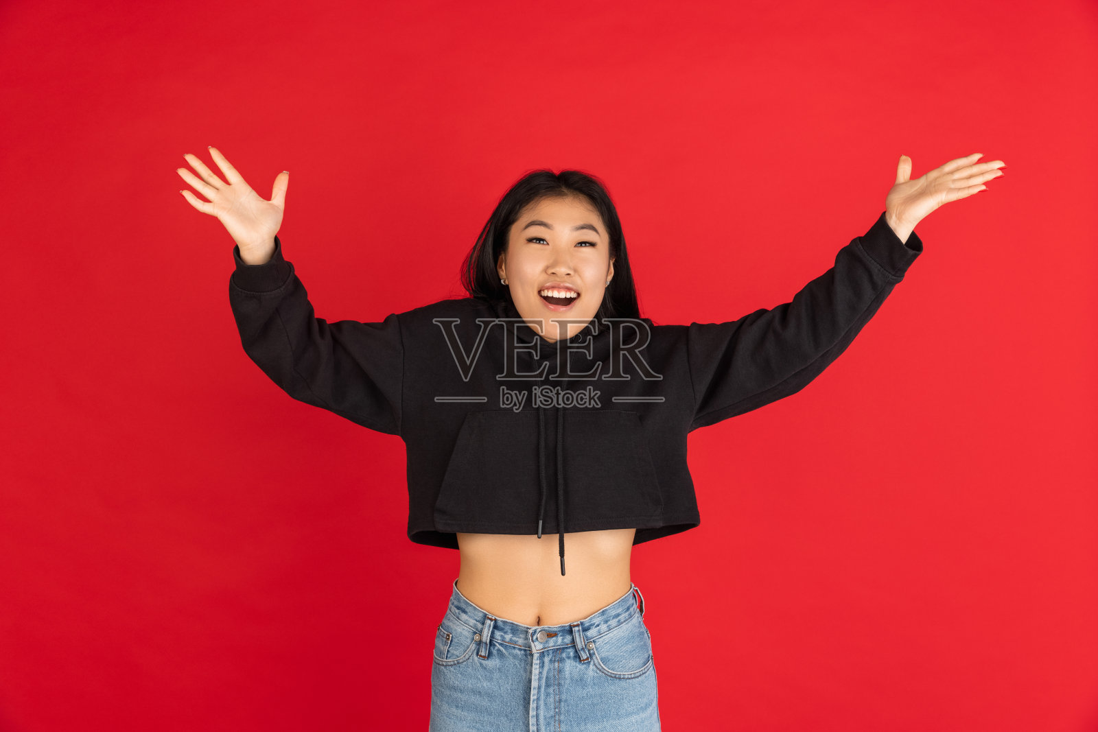 亚洲年轻女子的肖像孤立在红色工作室背景。照片摄影图片