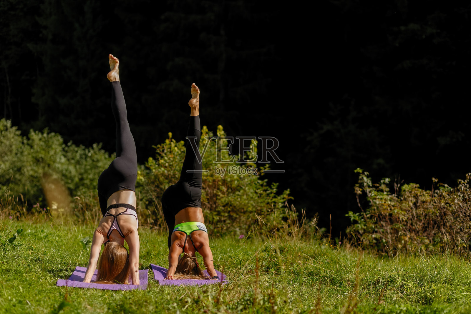 健身女性在一个公园练习瑜伽的三角姿势。照片摄影图片