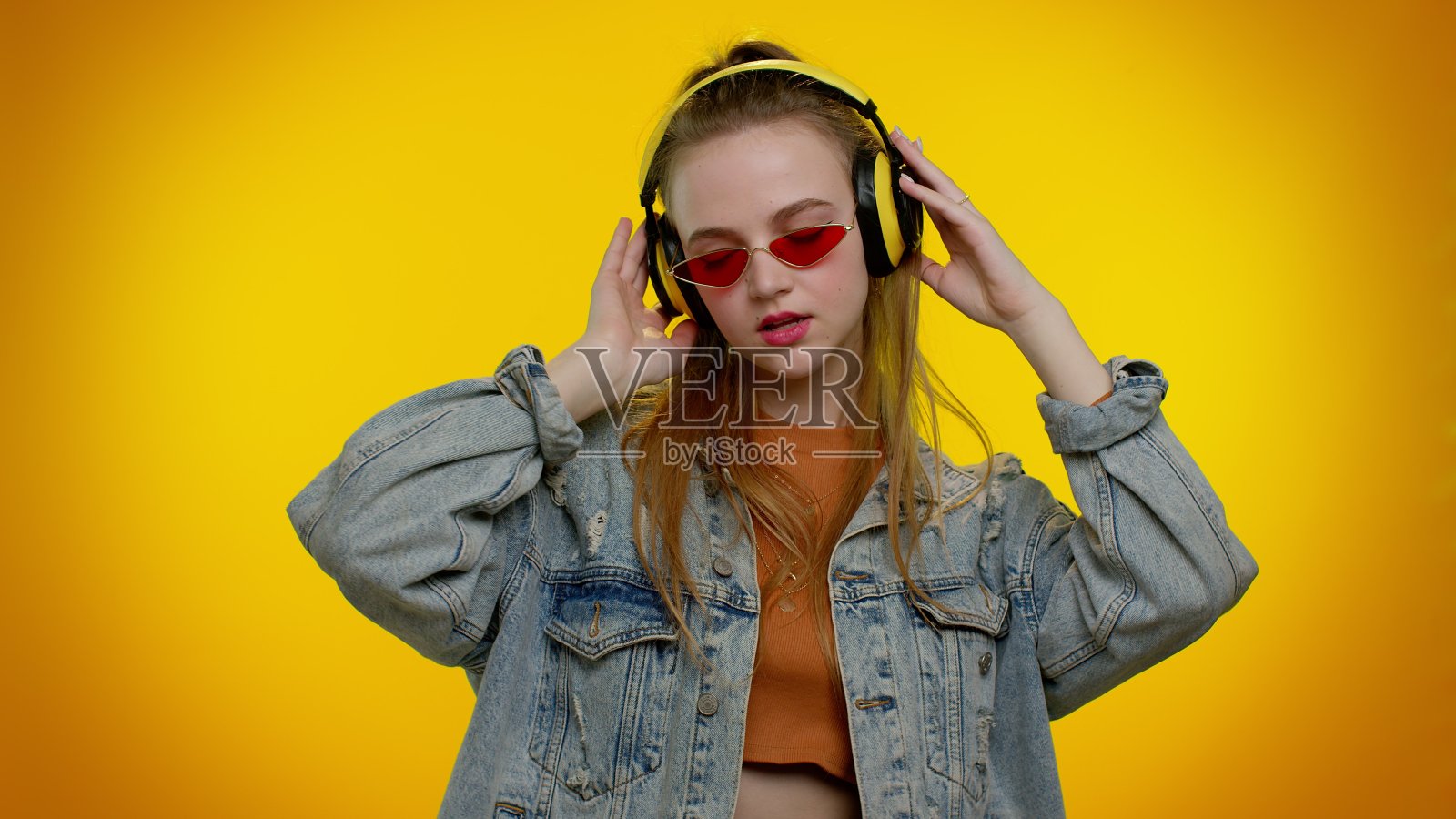 欢快迷人的女孩听音乐通过耳机和跳舞迪斯科鬼混有乐趣照片摄影图片