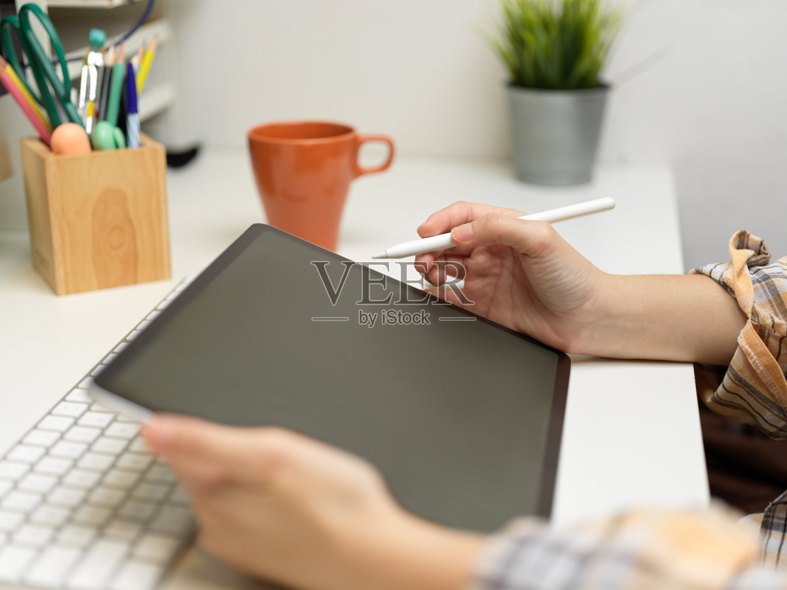 女性自由职业者工作与数码平板电脑桌上文具和马克杯照片摄影图片