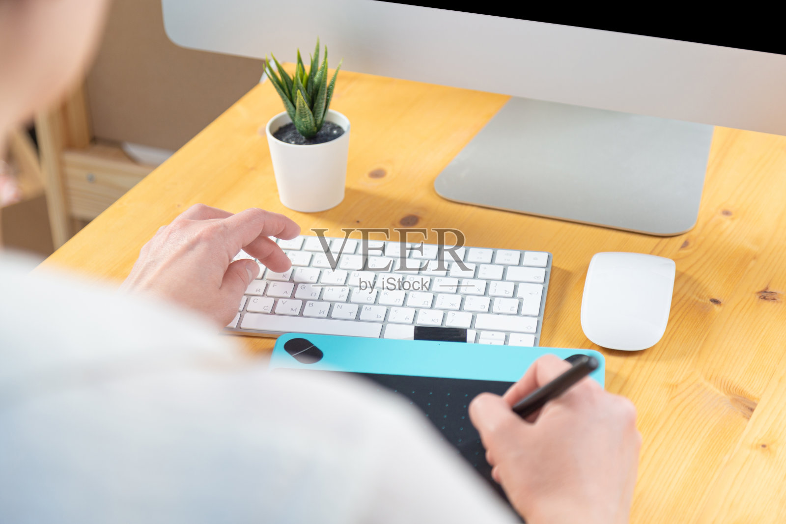 特写女性的手使用数字图形平板电脑和手写笔,而在现代办公室工作照片摄影图片