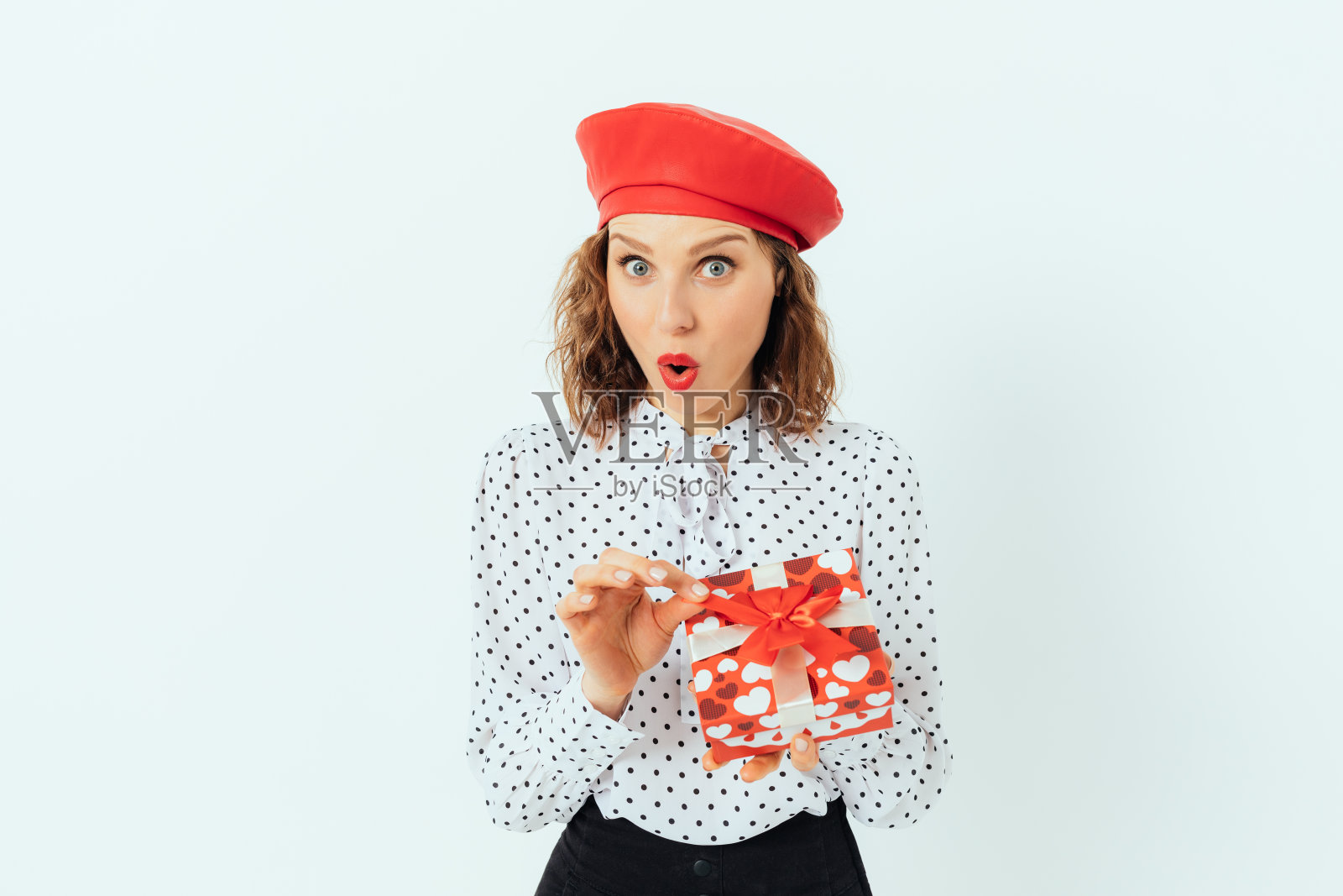 惊讶的年轻女子穿着优雅的红色贝雷帽照片摄影图片