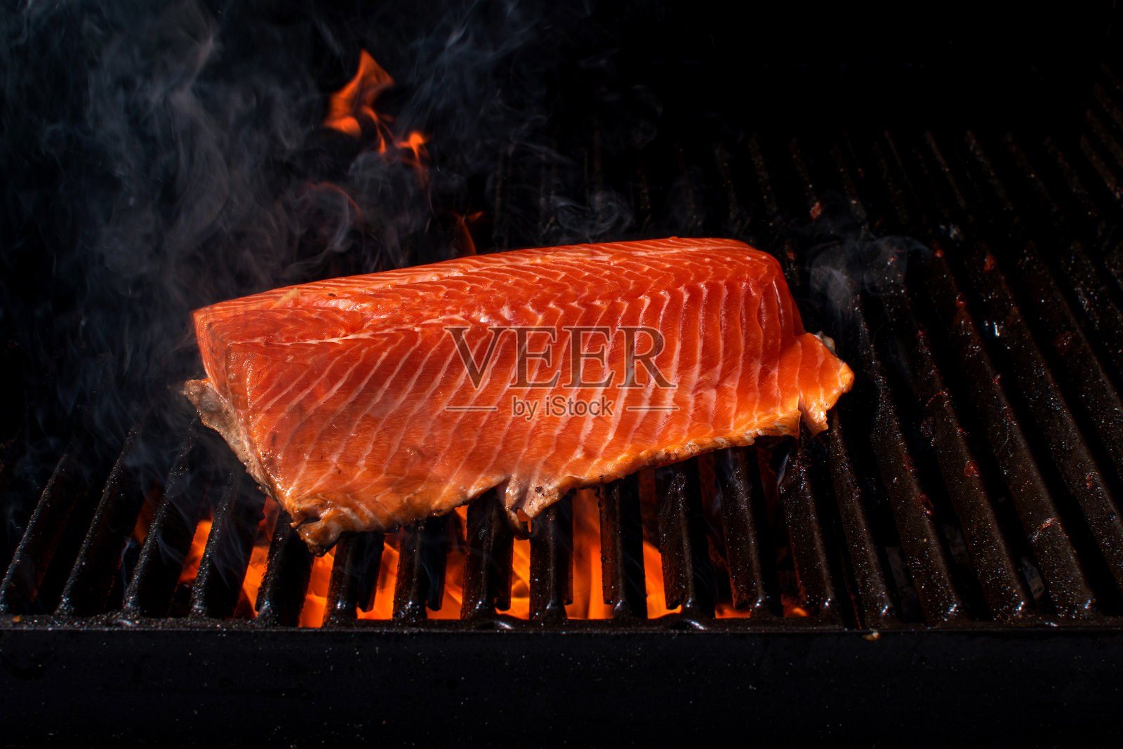 三文鱼片烧烤架烧烤与烟。照片摄影图片