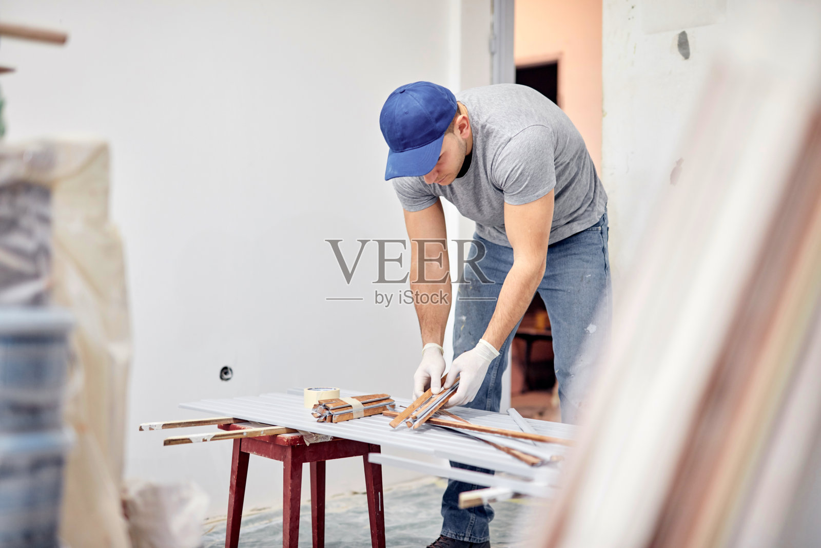 年轻的成年人在DIY预算装修他的新家公寓。照片摄影图片