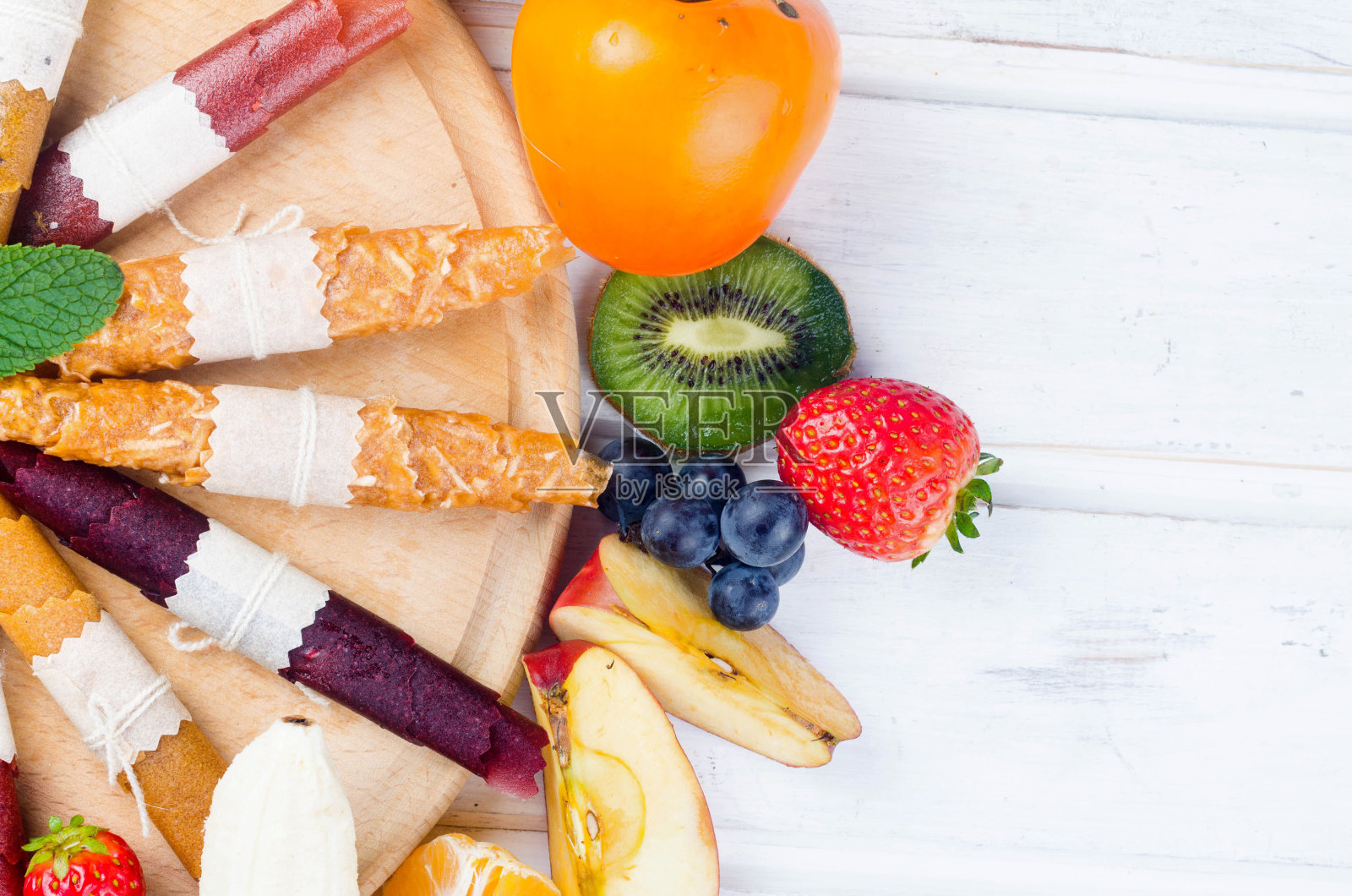 灰色背景下的各种成熟水果和干薯片。照片摄影图片