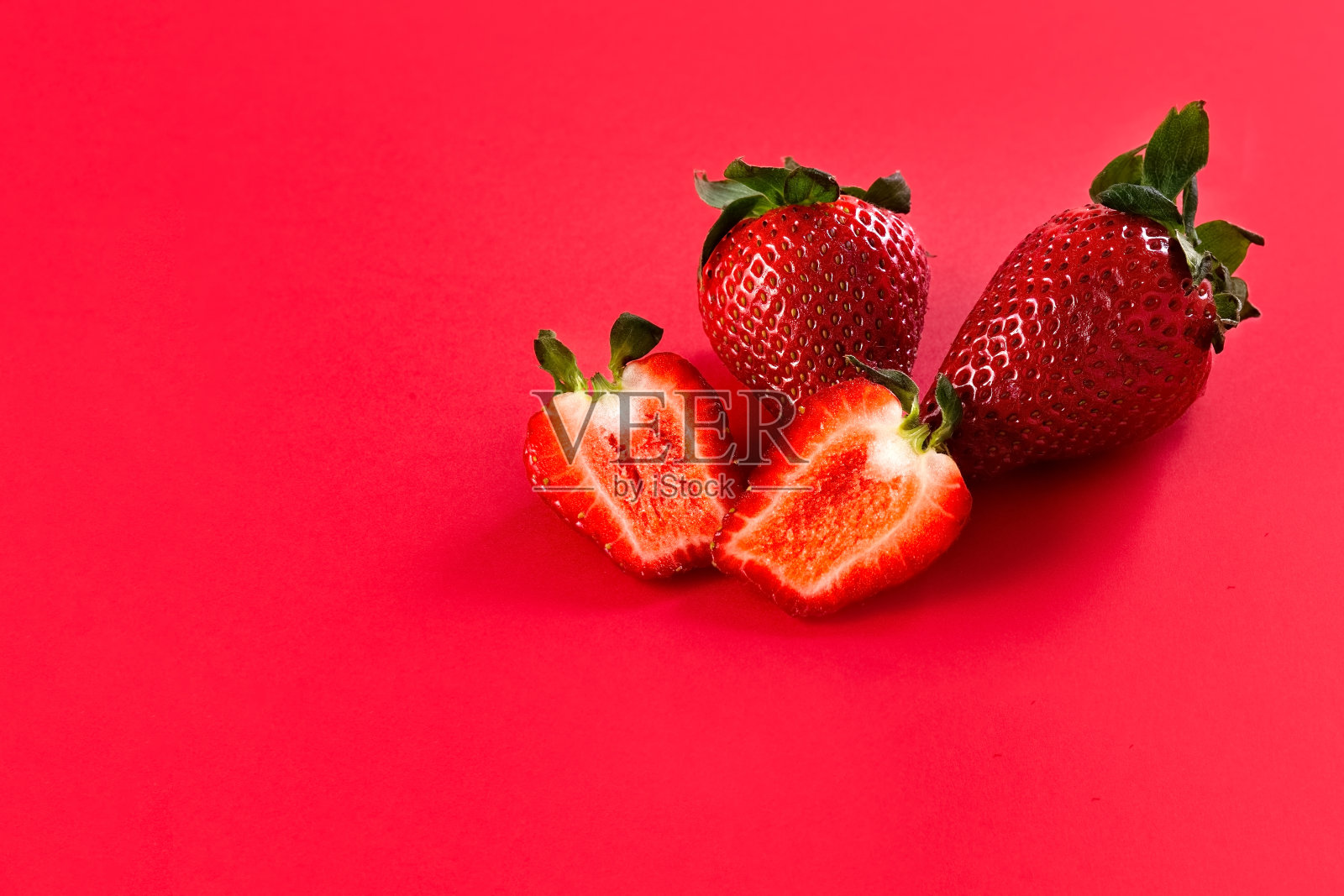 草莓。红色背景上的新鲜草莓。照片摄影图片