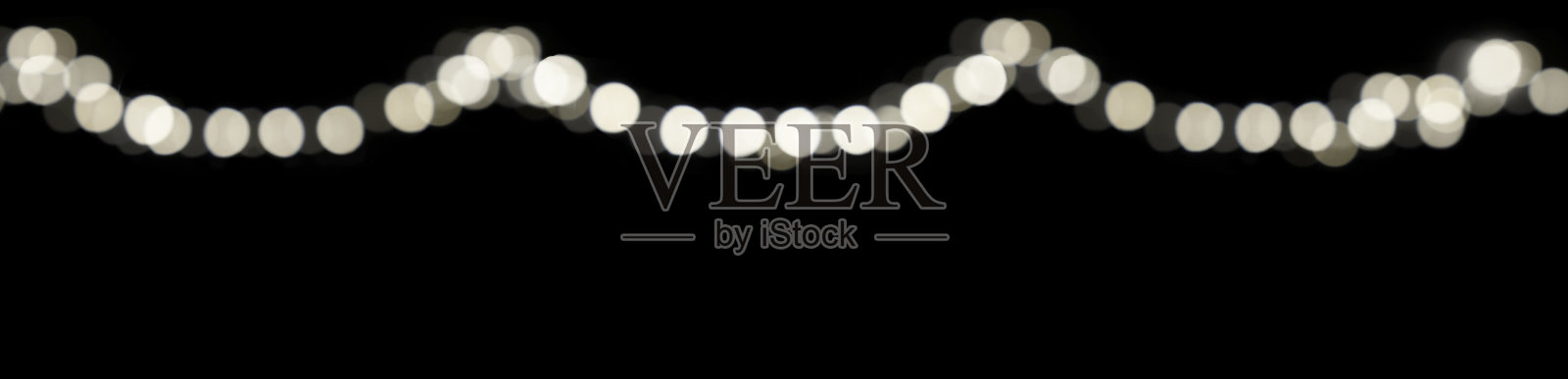 抽象模糊的光点书架在节日的黑暗背景为封面页,在晚上用灯光装饰。照片摄影图片