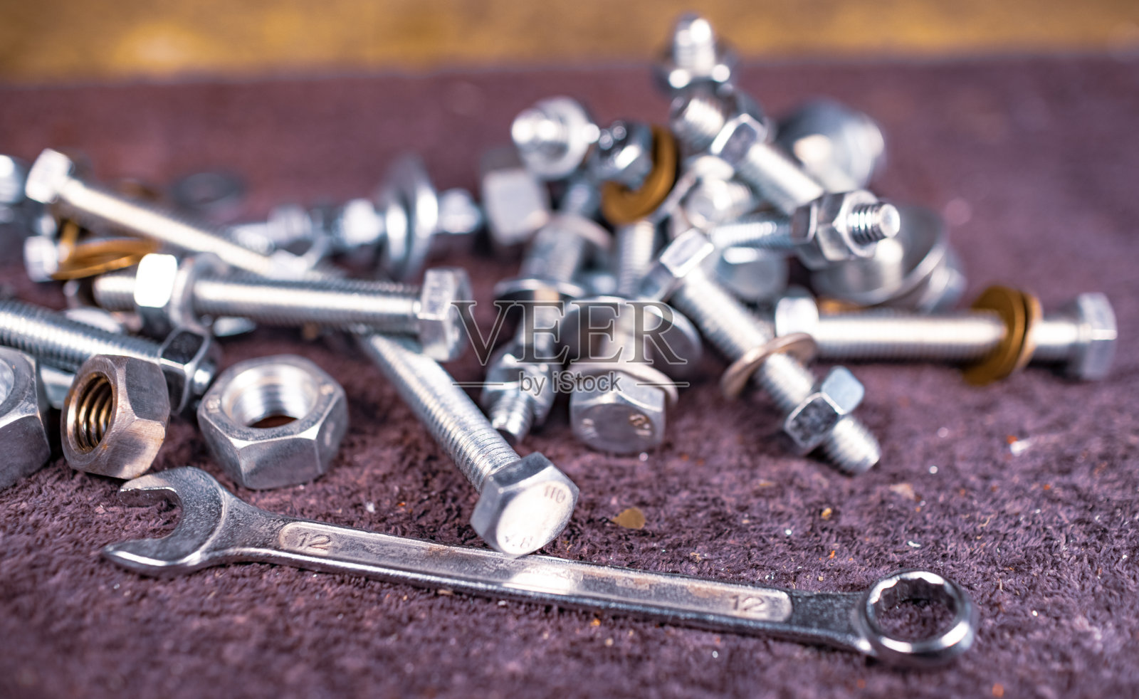 装配工的工作台上放着金属螺母、螺栓和扳手照片摄影图片