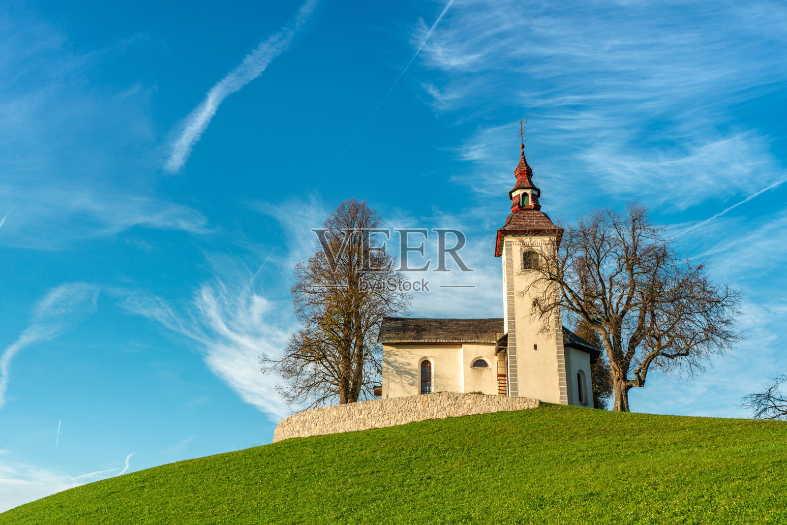 斯维提托马兹,斯洛文尼亚——斯科夫加洛卡地区的斯维提托马兹(圣托马斯)教堂日落时的景象,清澈的金色和蓝色的天空。斯洛文尼亚阿尔卑斯山的秋天照片摄影图片