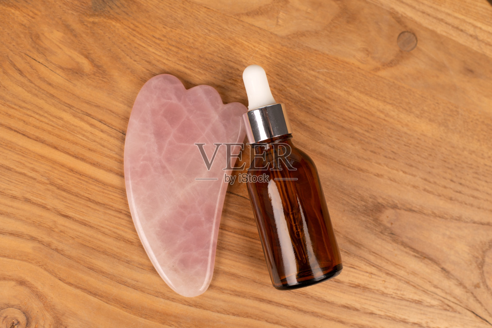 刮痧工具以玻璃瓶血清为背景。用刮痧概念按摩。俯视图照片摄影图片