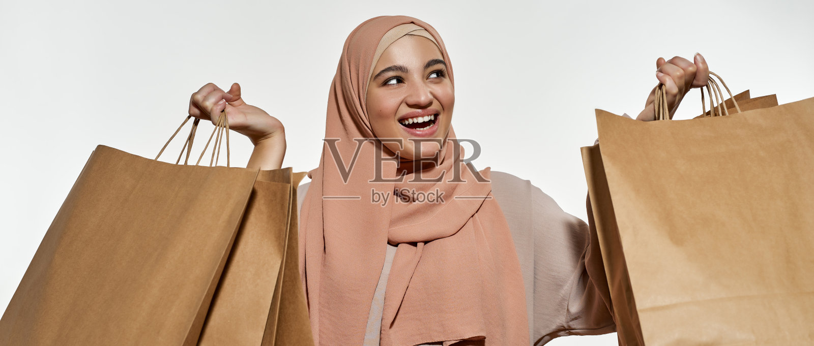 快乐的阿拉伯小女孩的肖像拿着包照片摄影图片