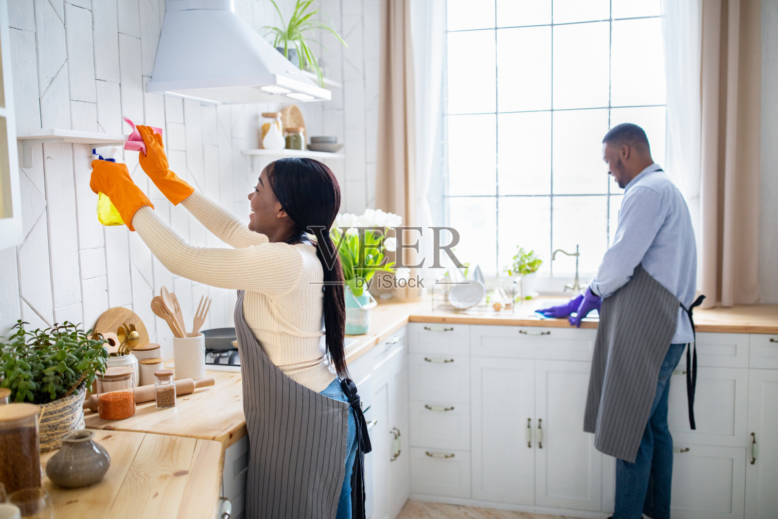 一对千禧一代黑人夫妇一起打扫厨房,做家务,享受自由空间。清理服务照片摄影图片