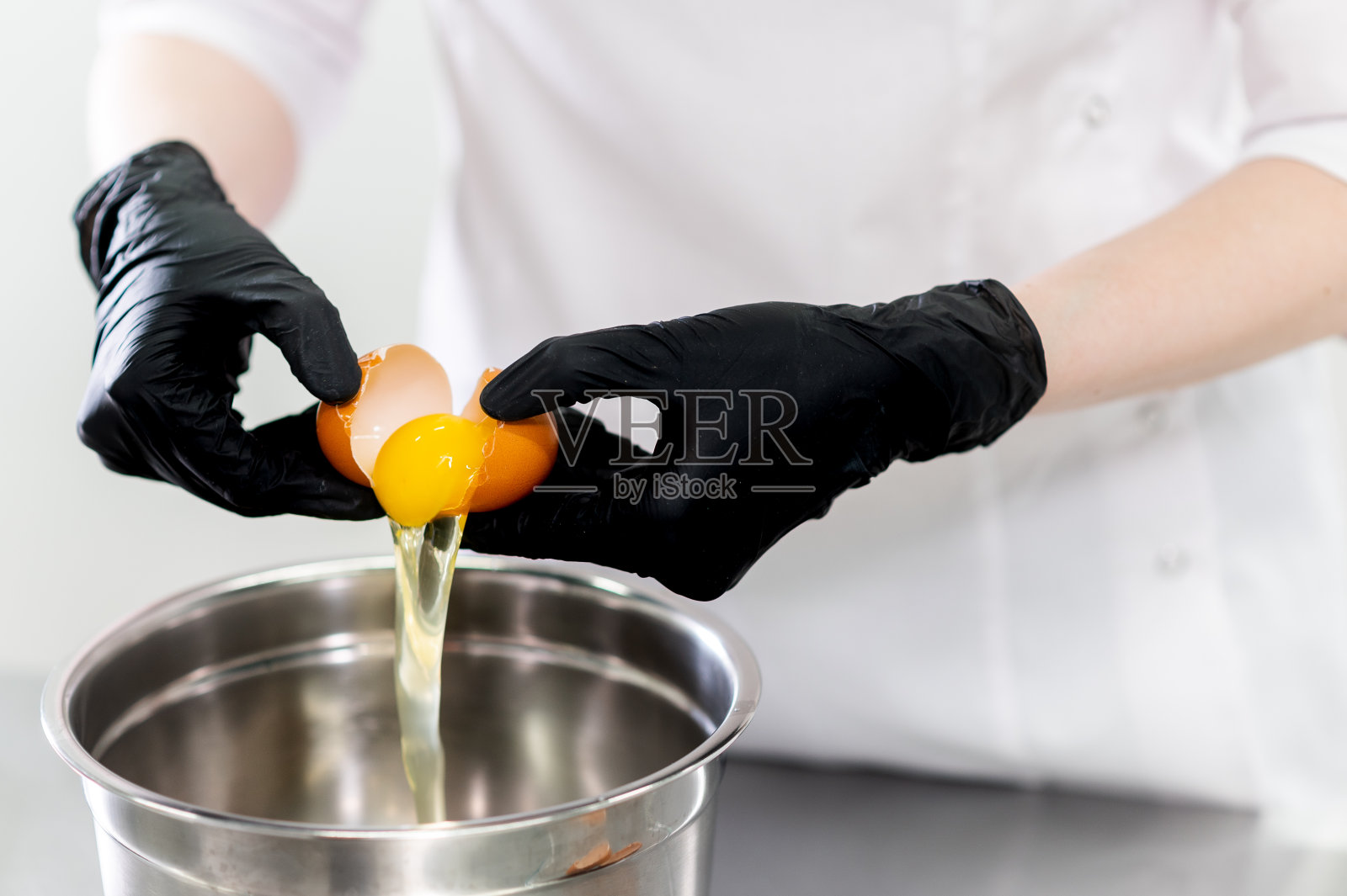 友好微笑的女性专业糖果师的肖像,用糕点袋顶奶油杯蛋糕照片摄影图片