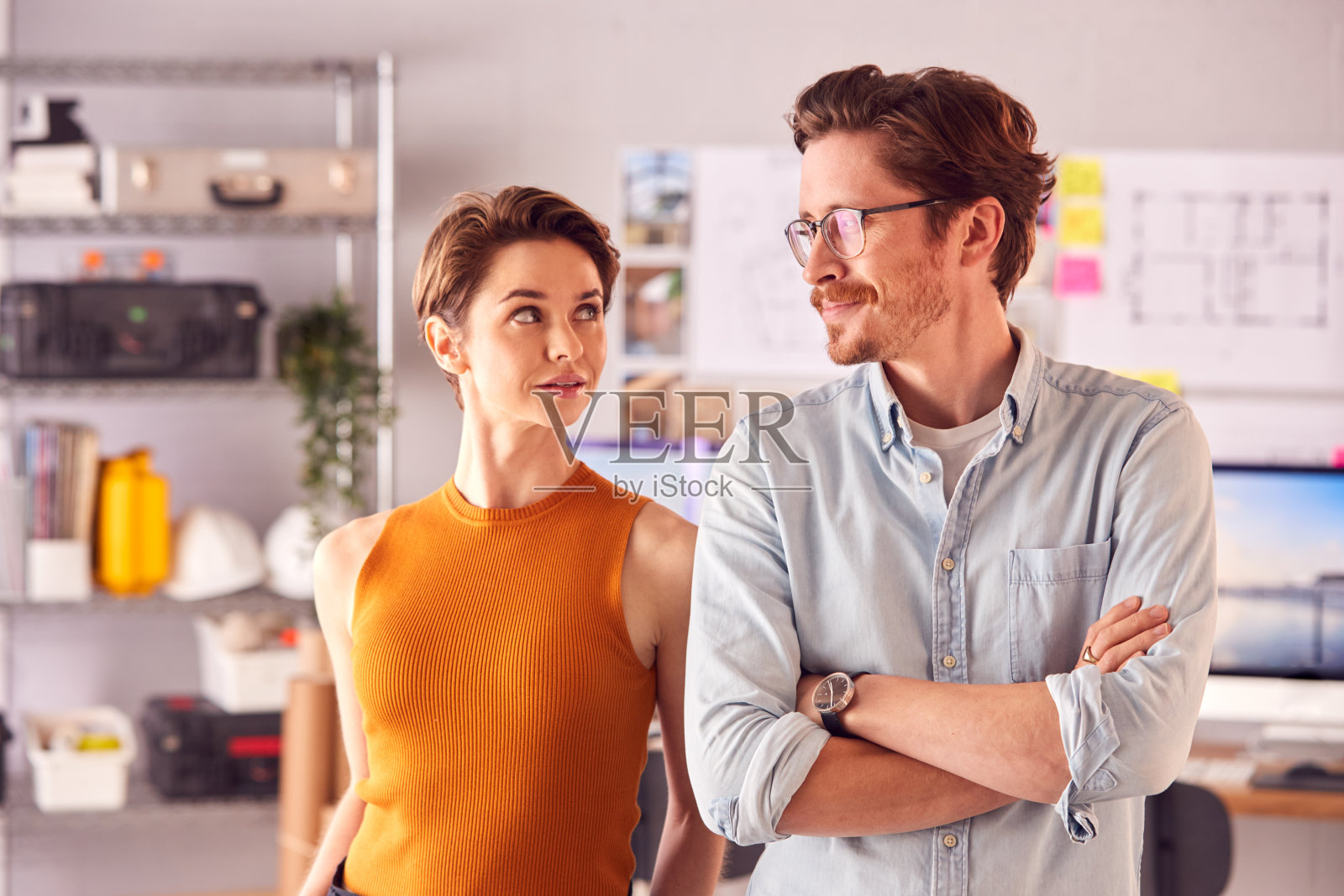 男性和女性建筑师在办公室站在桌子旁的肖像照片摄影图片