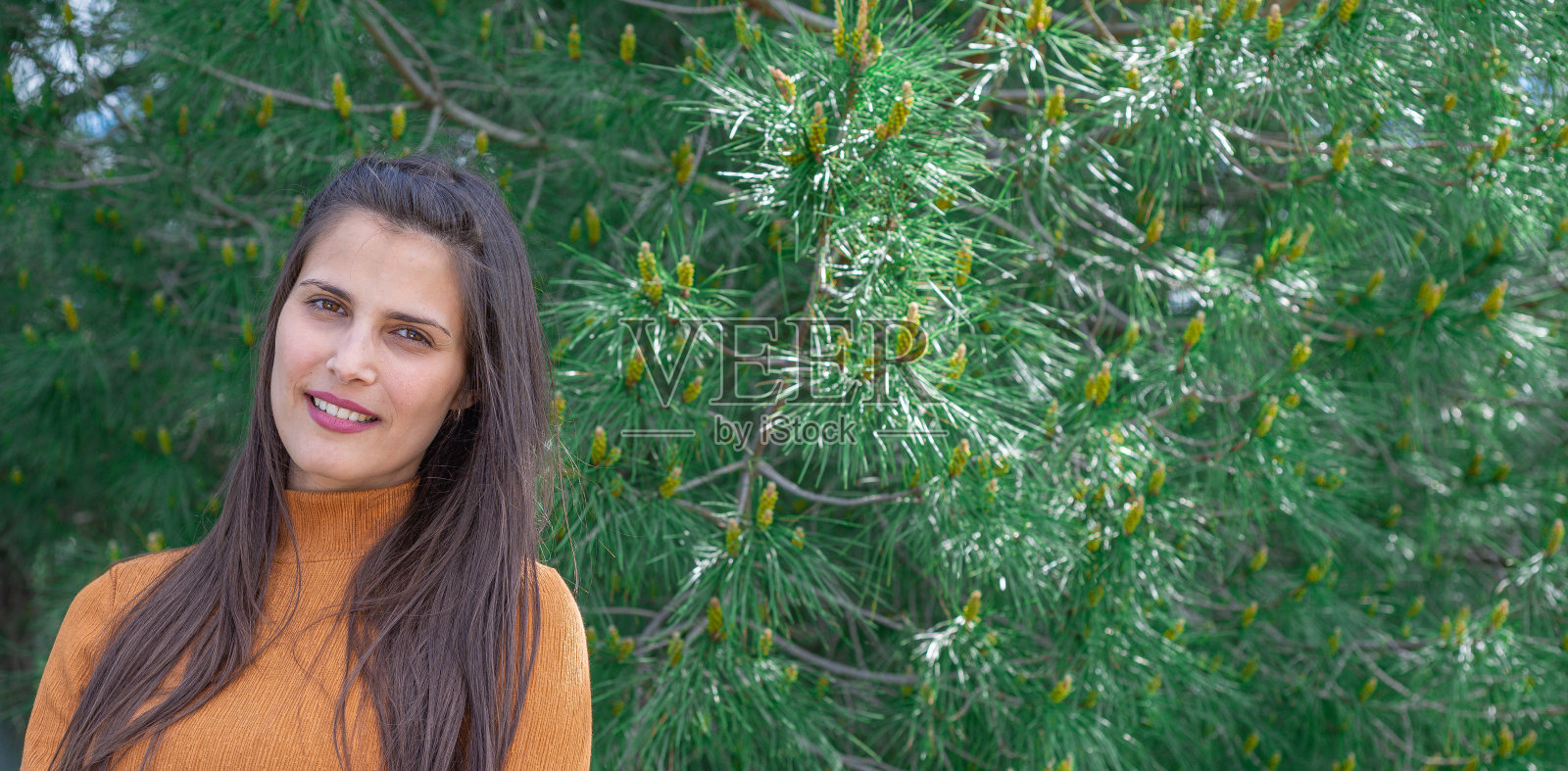 肖像上迷人的女孩穿着橙色的t恤,在大自然中,以一个山村为背景照片摄影图片