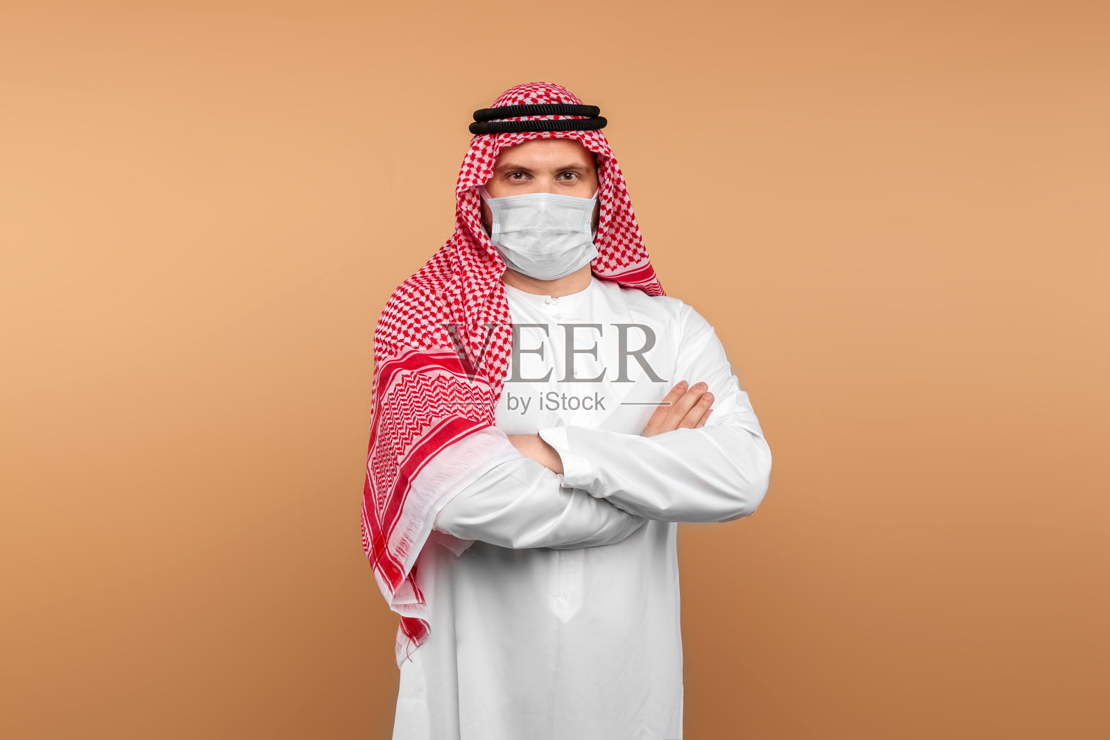 穿着民族服装戴着医用口罩的男人,防止传染病,留白照片摄影图片