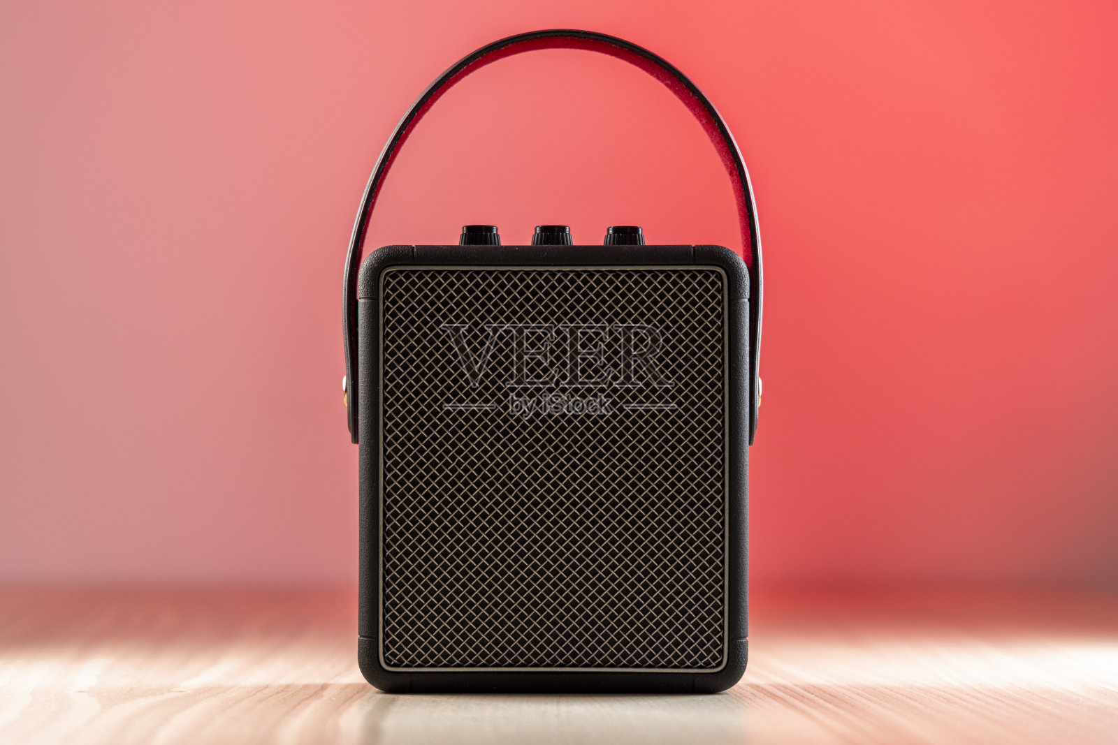 红色背景下的黑色蓝牙扬声器照片摄影图片