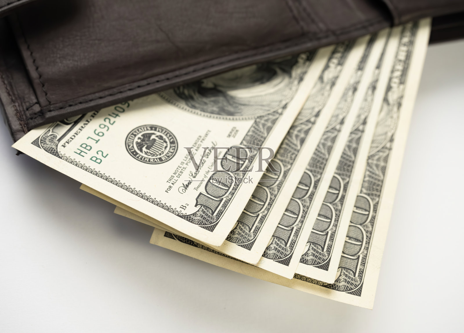 白色背景上装满钱的皮夹子。照片摄影图片