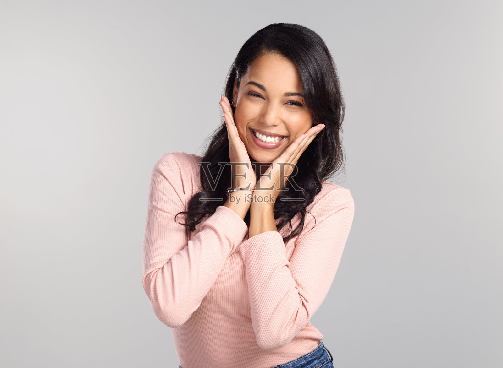 一个美丽的年轻女子在灰色背景下摆姿势的照片照片摄影图片