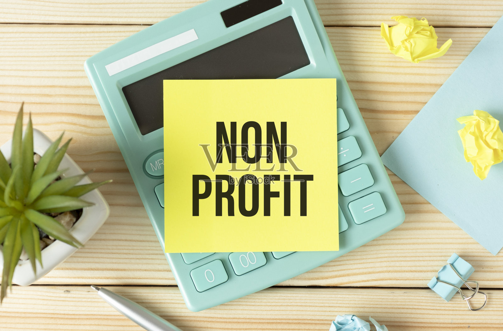 非营利性文字笔记本在台式机的笔、计算器旁边照片摄影图片