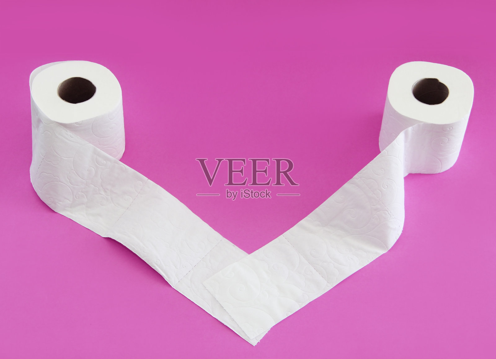 粉色背景的白色卫生纸卷照片摄影图片