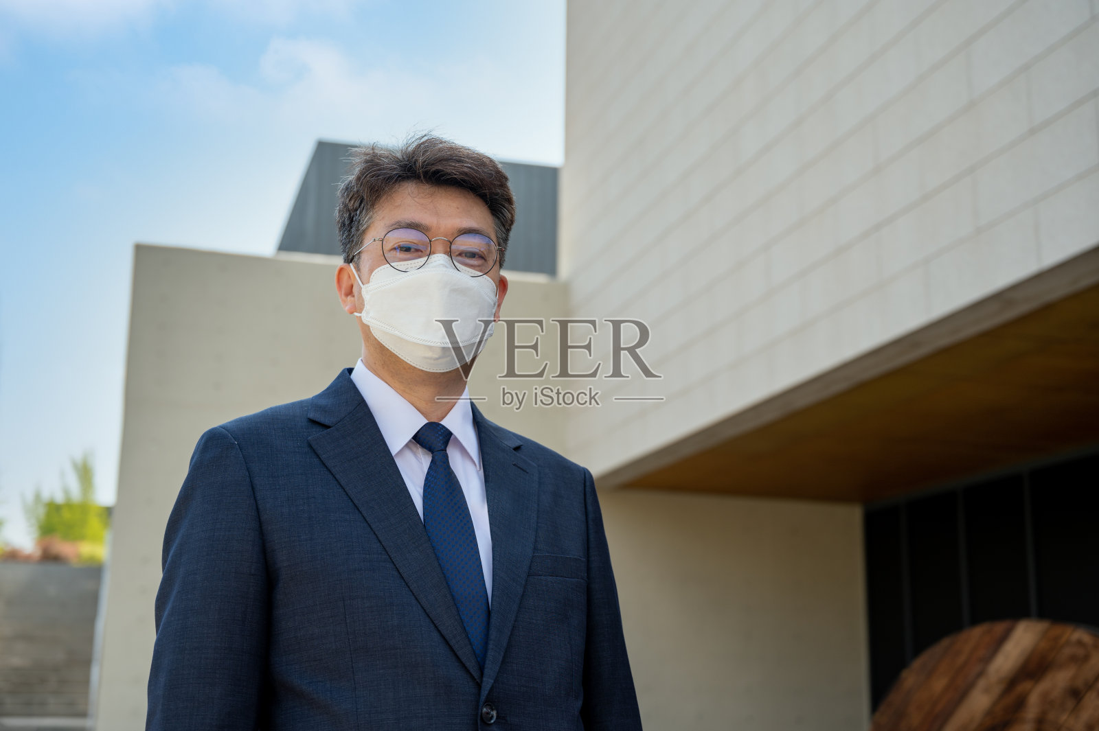 中年亚洲商人戴着面具。照片摄影图片